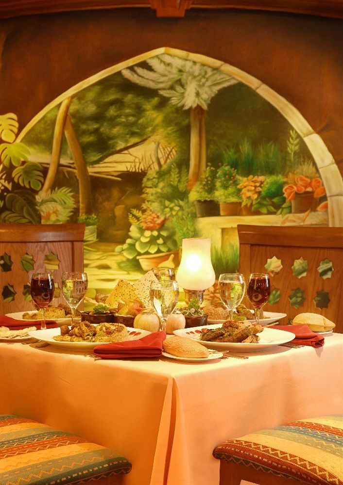 Sunrise Alex Avenue Hotel Alexandria Exterior foto The photo depicts a beautifully arranged dining table set against a vibrant mural of a garden. The table features a variety of dishes, likely a mix of main courses and sides, elegantly presented on white plates. There are also several glasses, includ