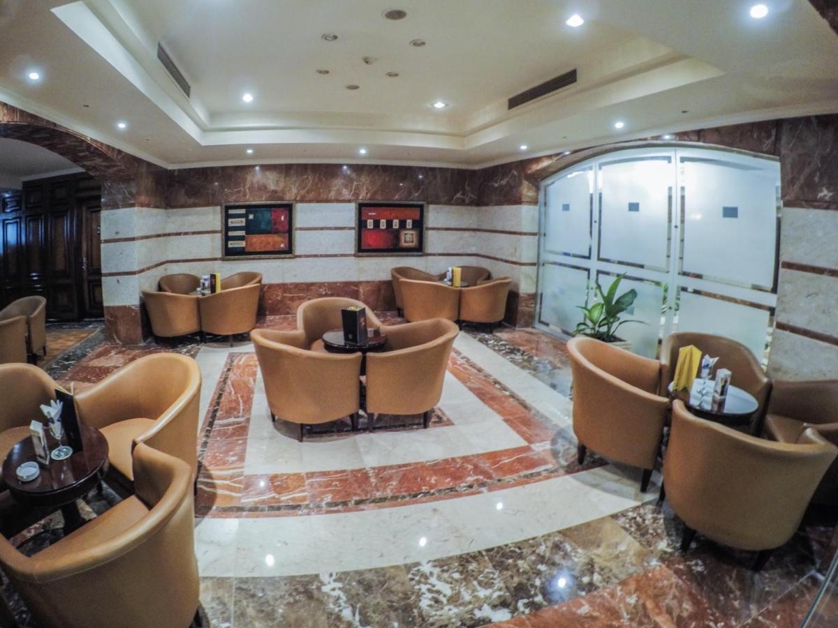 Sunrise Alex Avenue Hotel Alexandria Exterior foto The photo depicts a stylish lounge area with several comfortable seating arrangements. There are plush, curved chairs arranged around small tables, likely intended for coffee or casual gatherings. The floor features a polished marble design, and the 